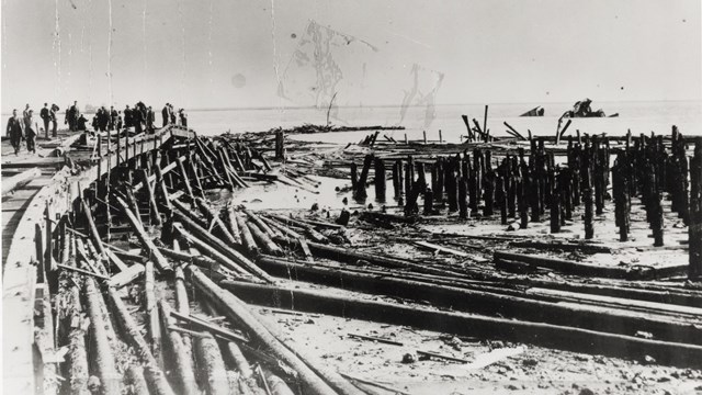 A historic photo of the disaster. Piles of wood from the pier can be seen. 